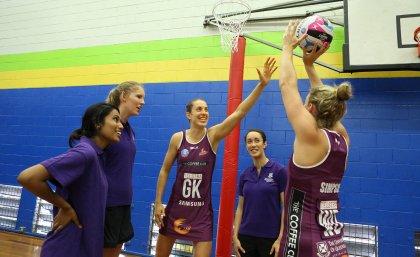 Bluejays players with Queensland Firebirds Laura Clemesha (L) and  Gabi Simpson (R)